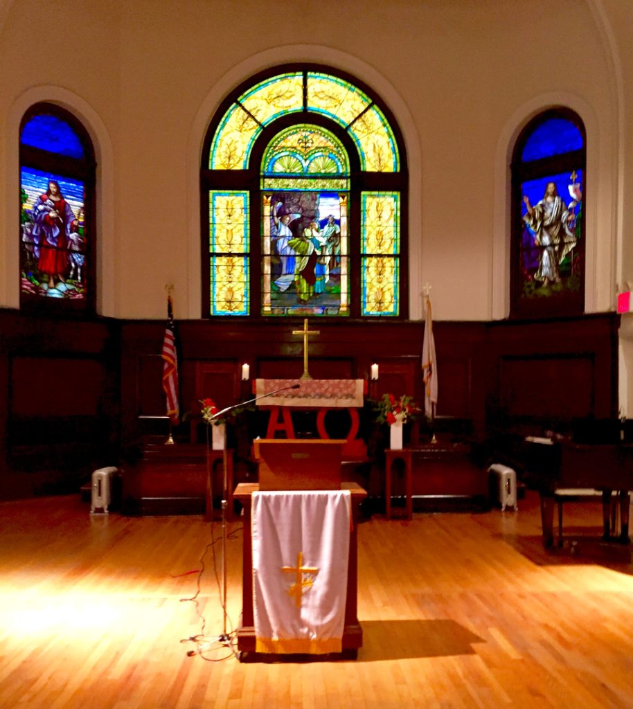 The altar area with memorial stained-glass windows.